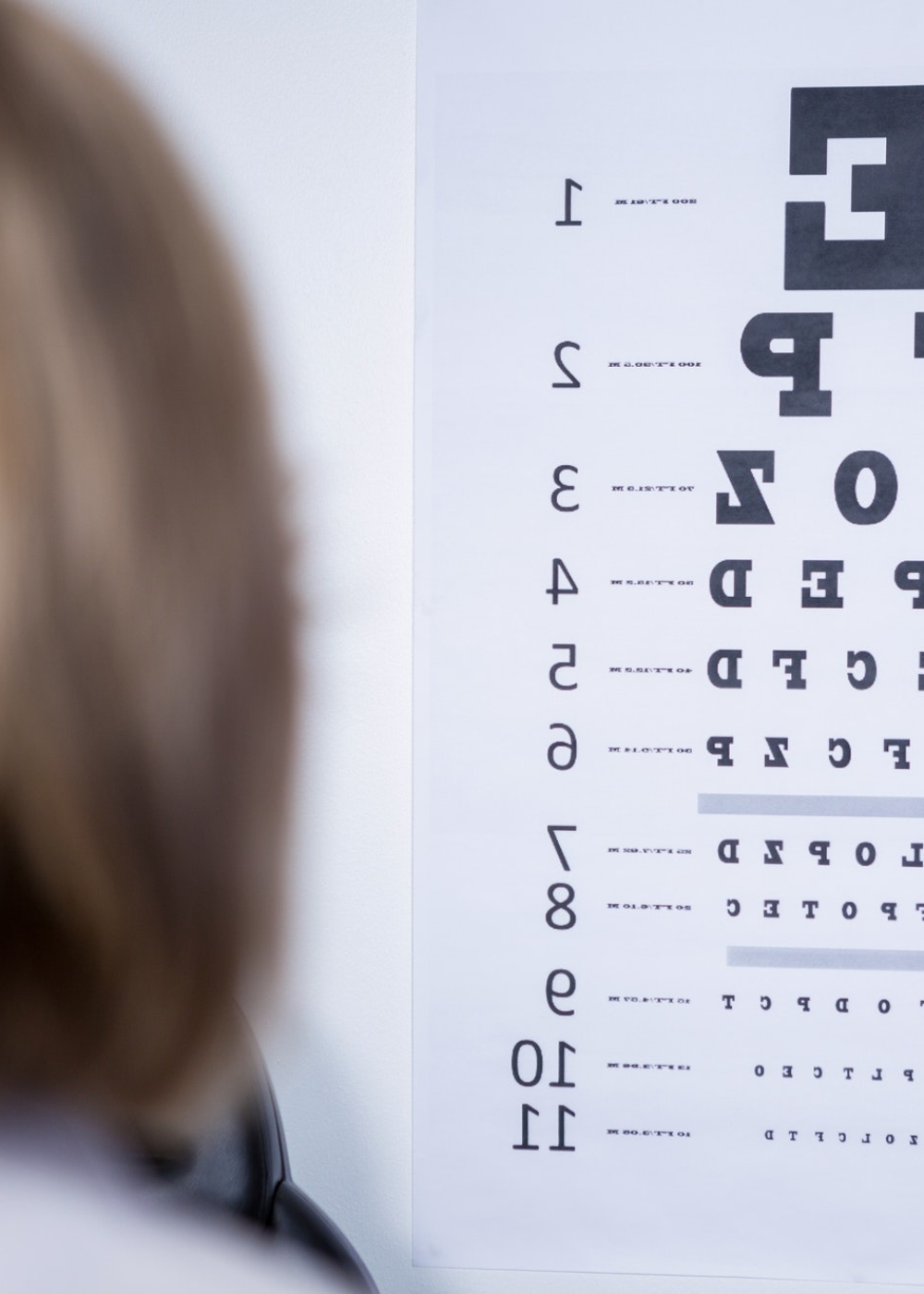 optometrist-looking-at-eye-chart-e1727356037684.jpg